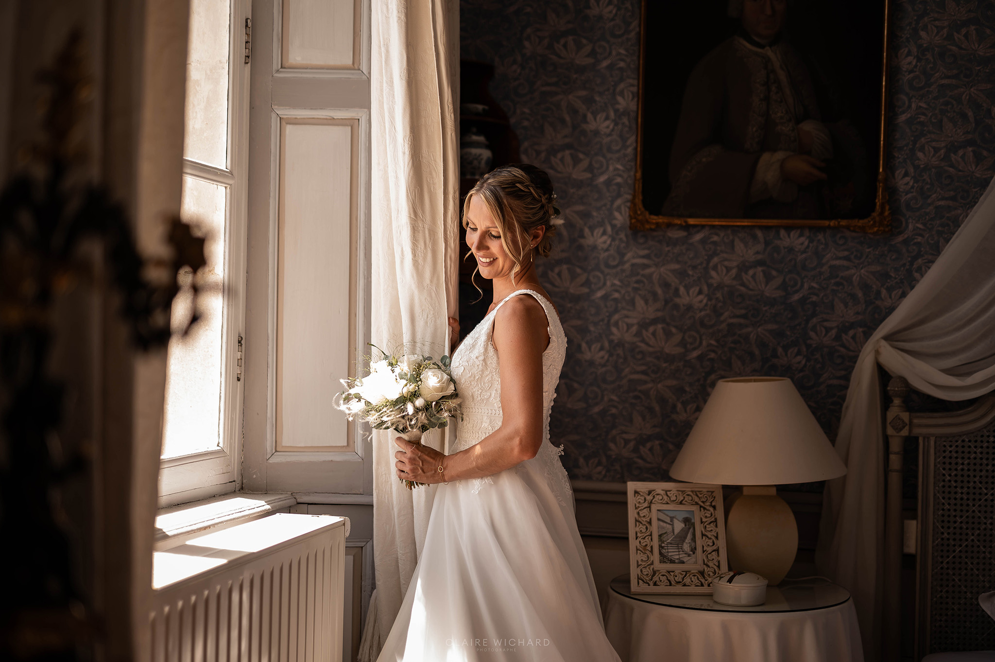mariée devant la fenêtre de sa chambre au chateau de autigny la tour. photographié par claire wichard