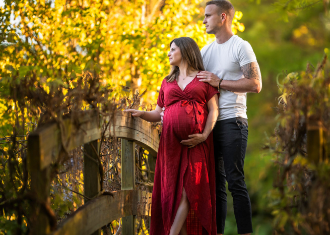 Futur papa et maman posant sur un pont en bois lors d'une séance photo de grossesse à Metz