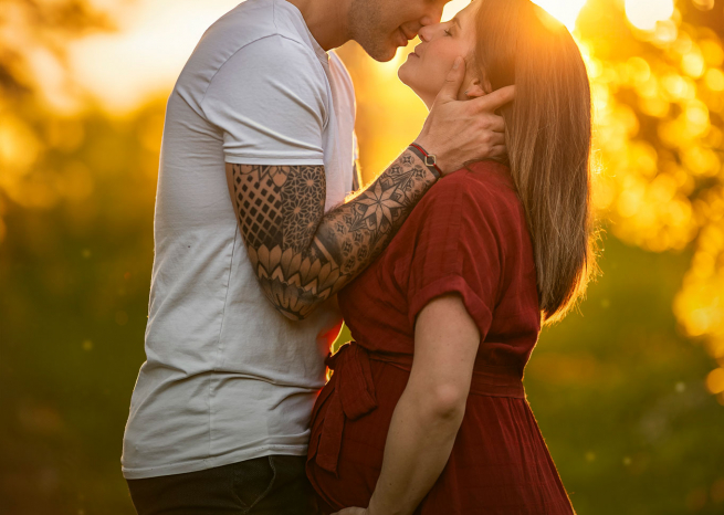 Séance photo de couple enceinte avec effets de lumière dorée au coucher du soleil à Metz
