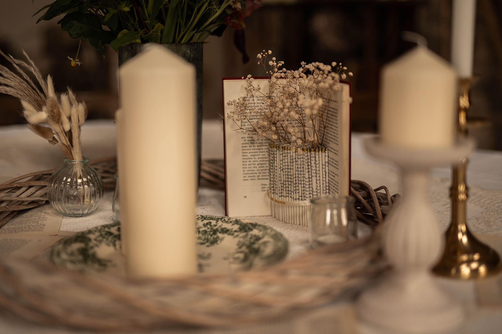 Détails de la décoration de table champêtre avec livres et bougies au Château Ferme d'Aboncourt