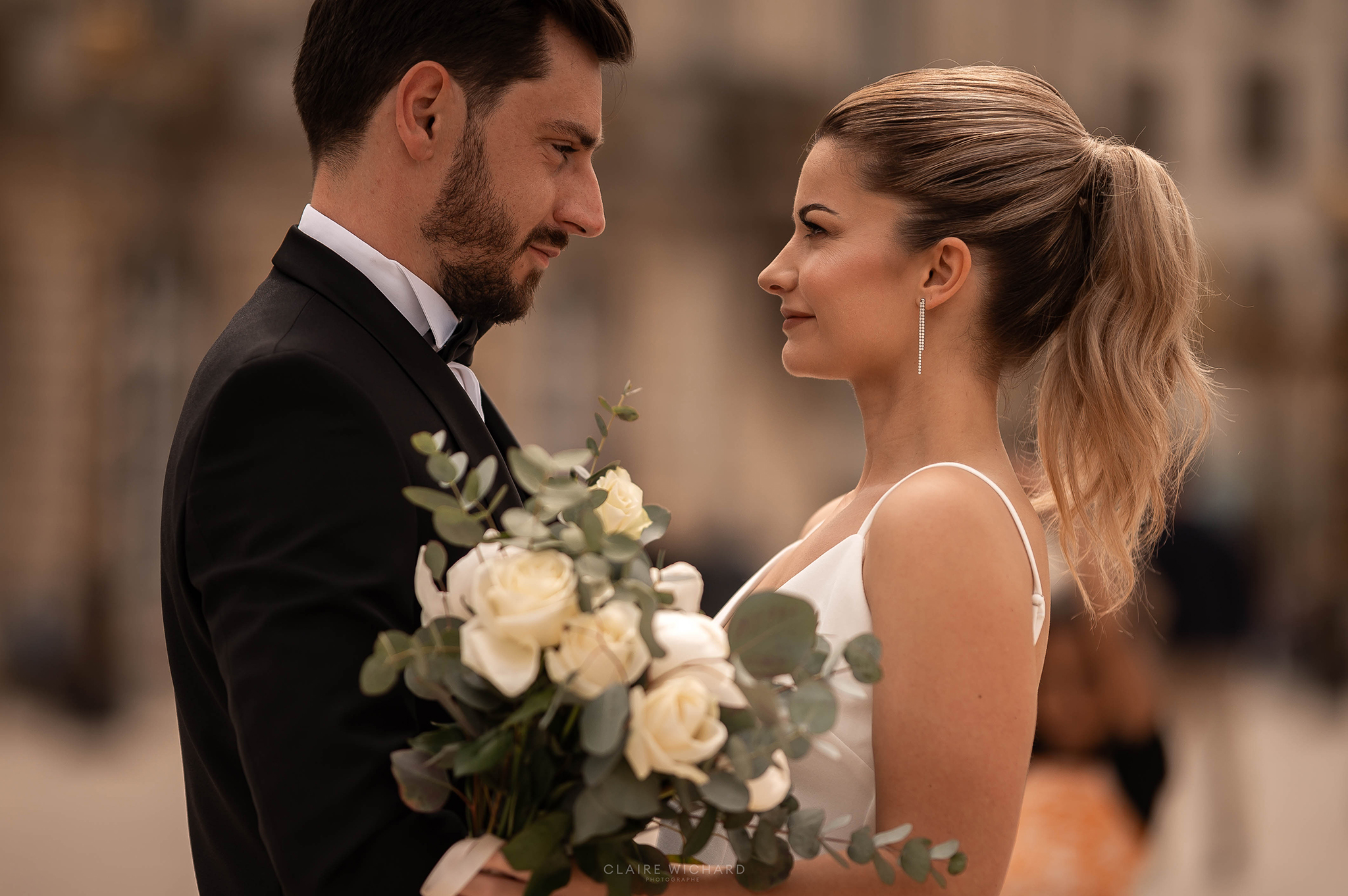 Gros plan intime d'un couple de mariés se regardant avec tendresse sur la Place Stanislas à Nancy
