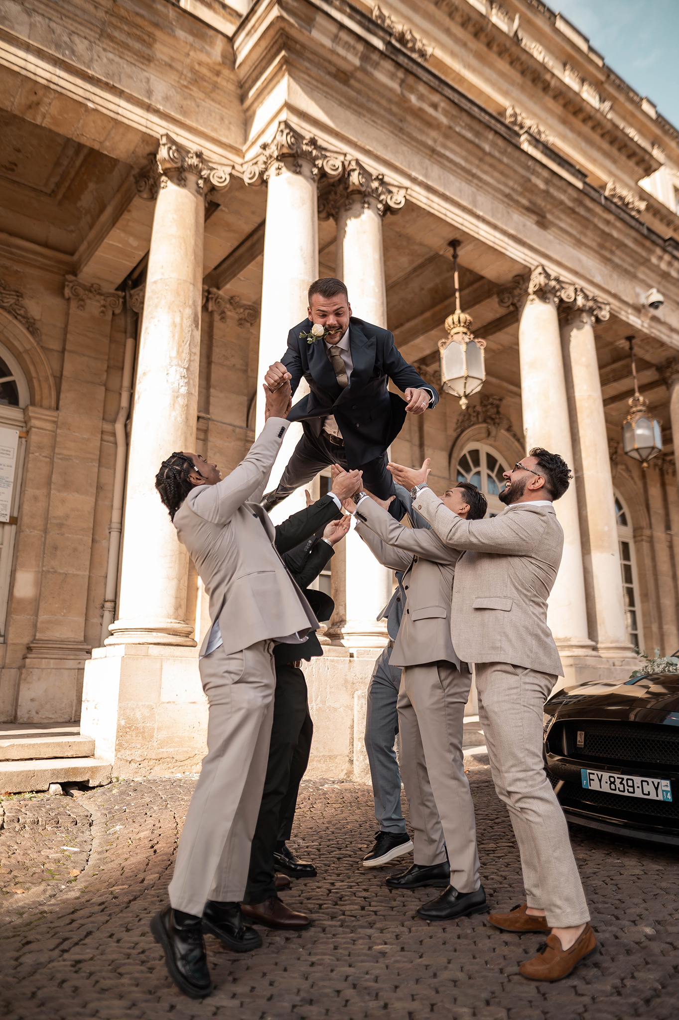 Séance photo dynamique au Palais du Gouvernement à Nancy : les garçons d'honneur lancent le marié en l'air