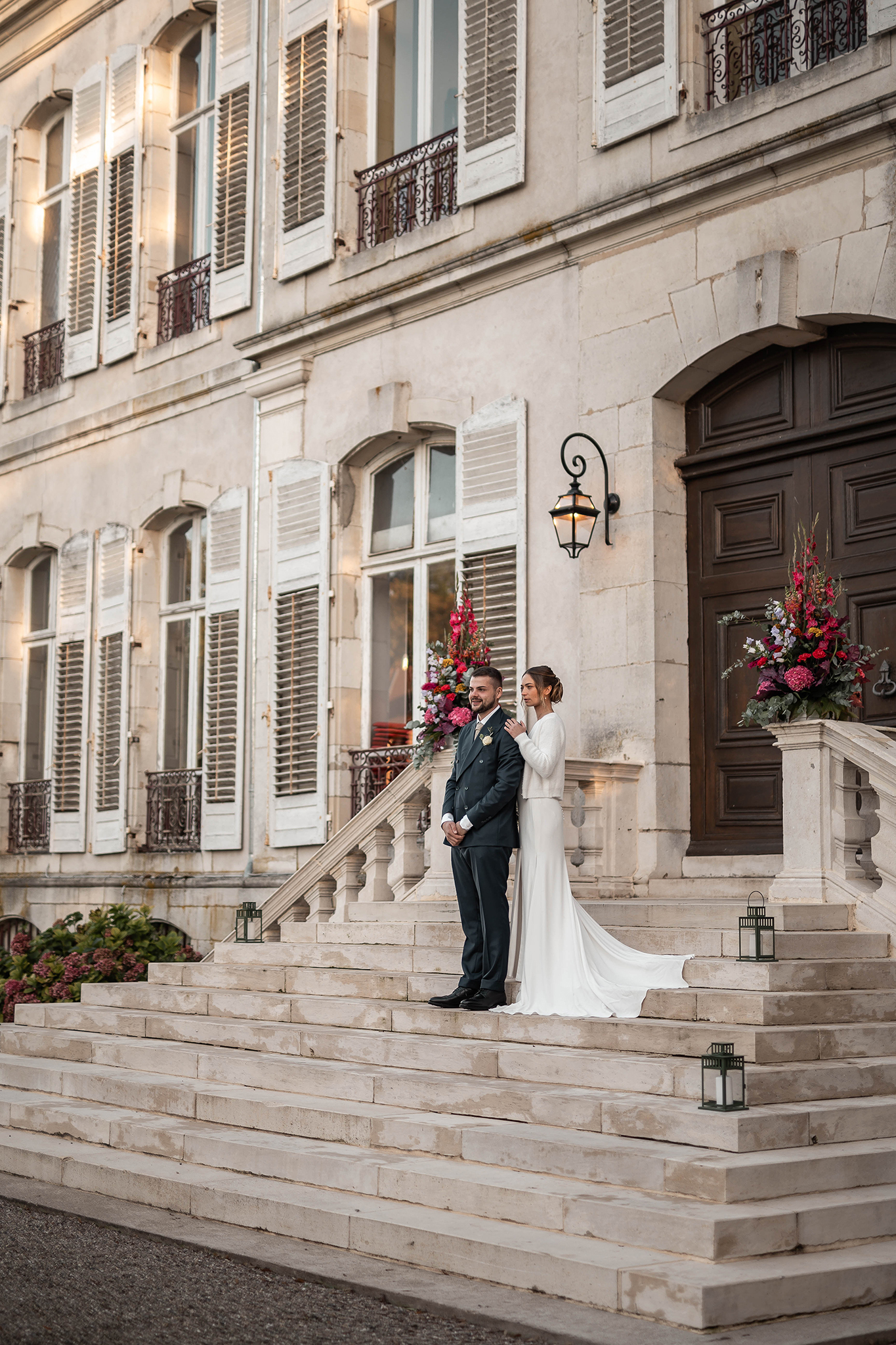 Couple de mariés élégant posant devant la porte monumentale du Château Ernest à Tantonville