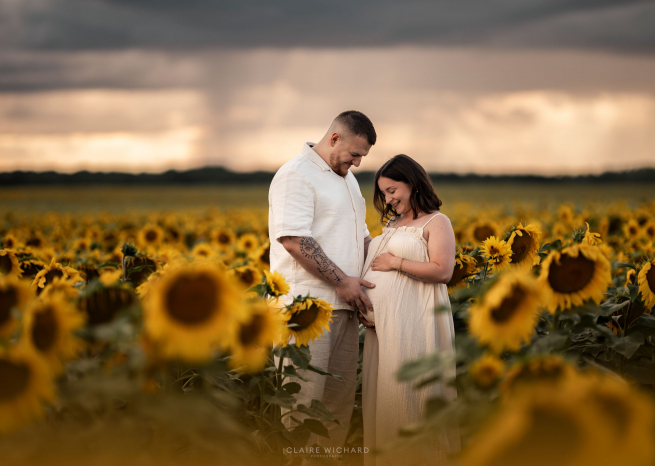 Moment de tendresse pour un couple attendant un enfant au milieu des tournesols, photographe lifestyle Nancy