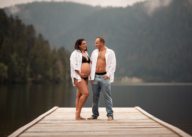 Couple attendant un enfant posant sur un ponton en bois devant un lac des Vosges