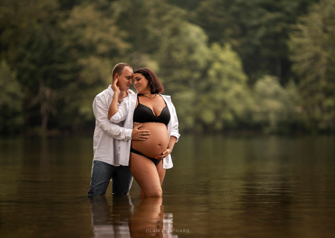 Futur papa et maman s'enlaçant dans un lac vosgien, photographe lifestyle Vosges