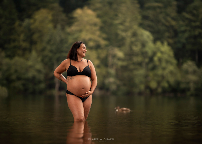 Femme enceinte en sous-vêtements noirs dans l'eau d'un lac des Vosges, style artistique