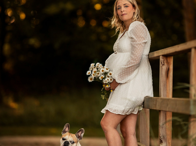 Photographe de grossesse et d'animaux, femme enceinte sur un pont en bois avec son chien bouledogue français