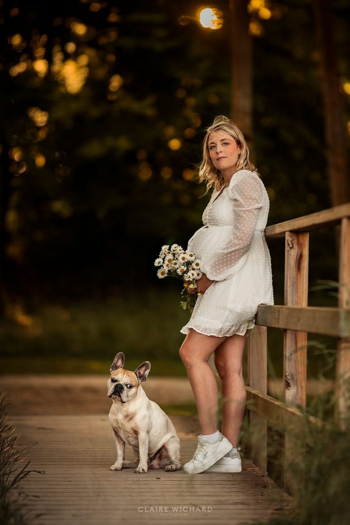 Photographe de grossesse et d'animaux, femme enceinte sur un pont en bois avec son chien bouledogue français