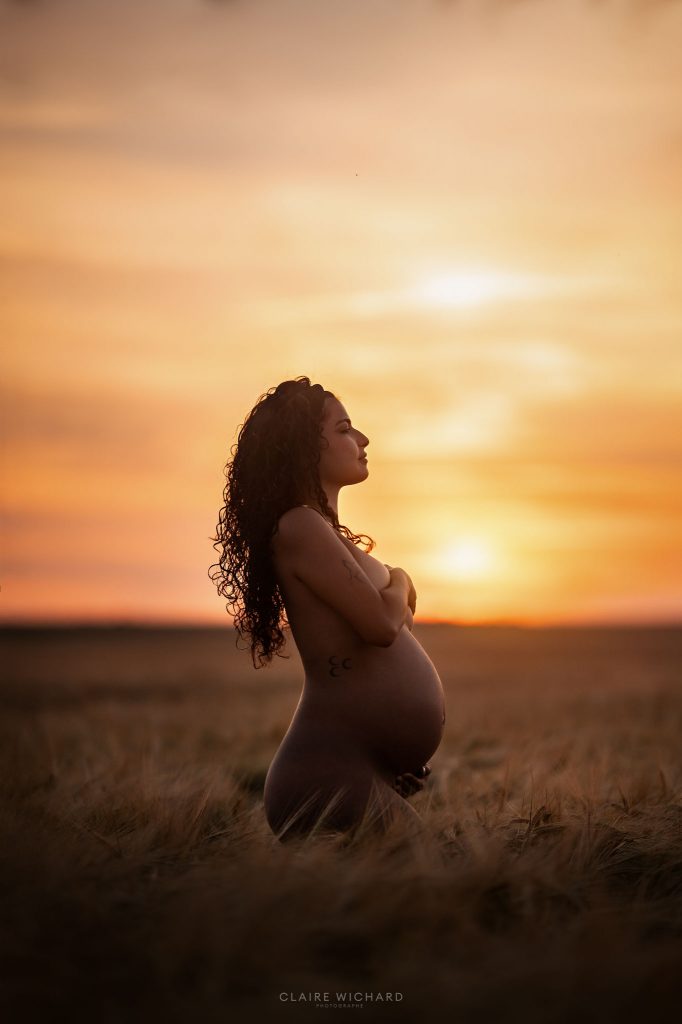 Silhouette d'une femme enceinte au coucher du soleil dans les champs près d'Essey-les-Nancy, photographe grossesse 54.