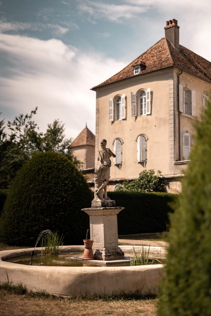 Vue de la fontaine et de la façade du Château d'Autigny-la-Tour, lieu de réception de prestige pour un mariage près de Nancy.
