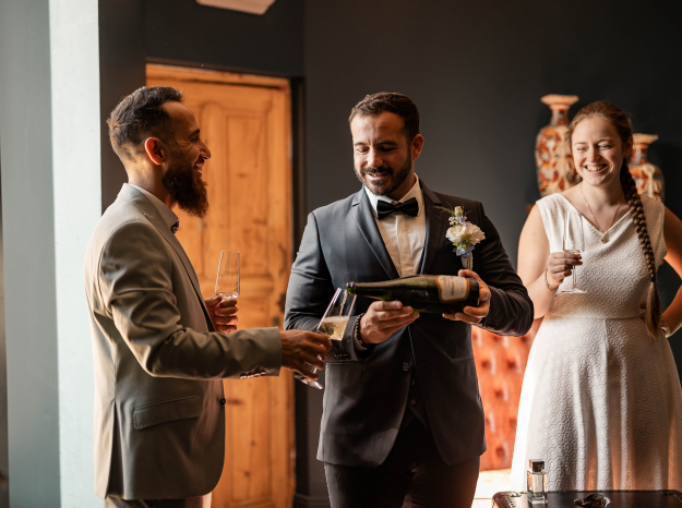 Reportage photo de mariage à Nancy : ambiance et discussions entre invités masculins lors d'un cocktail.