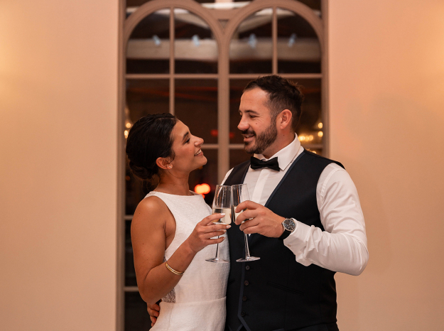 Photographe mariage Nancy : portrait élégant de mariés posant devant une grande porte vitrée à l'intérieur