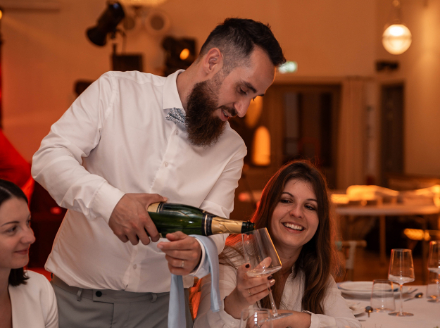 Reportage photo de mariage en Lorraine : serveur servant du vin pendant le repas