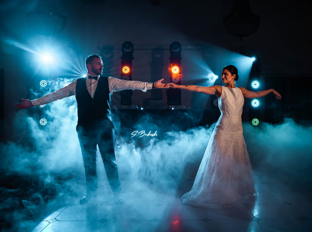 Mariés pendant l'ouverture de bal lors d'un mariage dans une fumée bleu