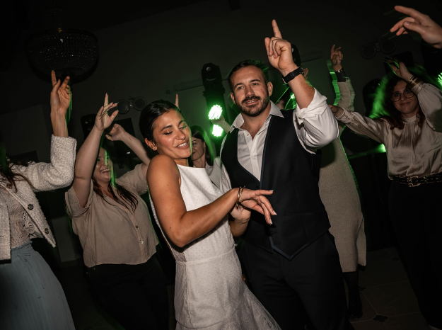 Reportage photo mariage Nancy : les mariés dansant avec enthousiasme pendant la soirée.