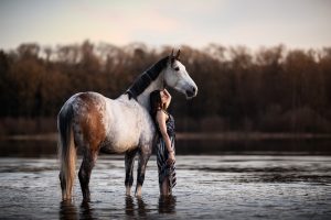 Portrait artistique d'une femme et son cheval dans l'eau du Lac de Bouzey, photographe professionnel Vosges.