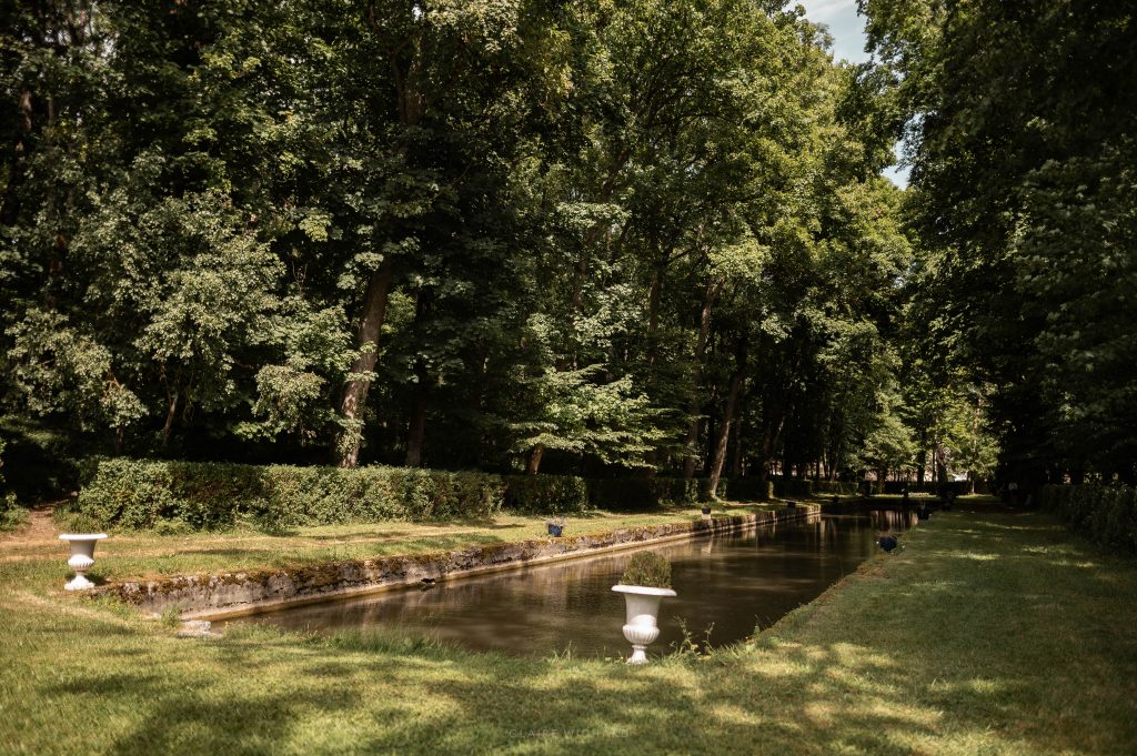 Allée de verdure et canal d'eau historique dans le parc du Château d'Autigny-la-Tour.