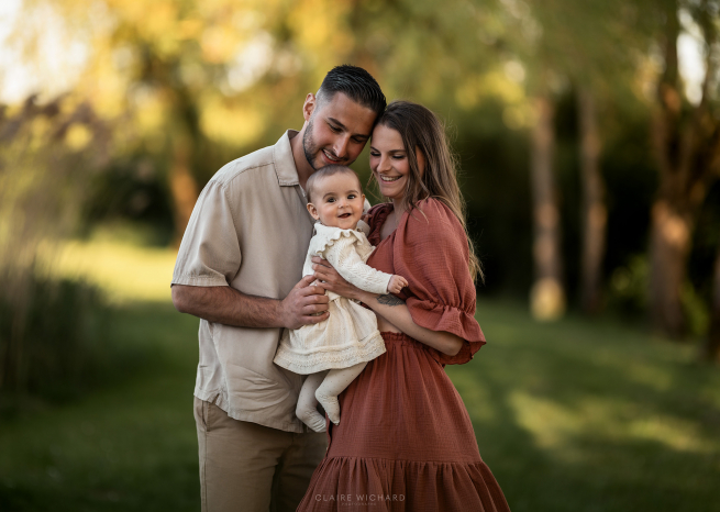 Séance photo lifestyle en famille près de Nancy, avec de jeunes parents et leur bébé souriant au bord de l'étang d'Housseville