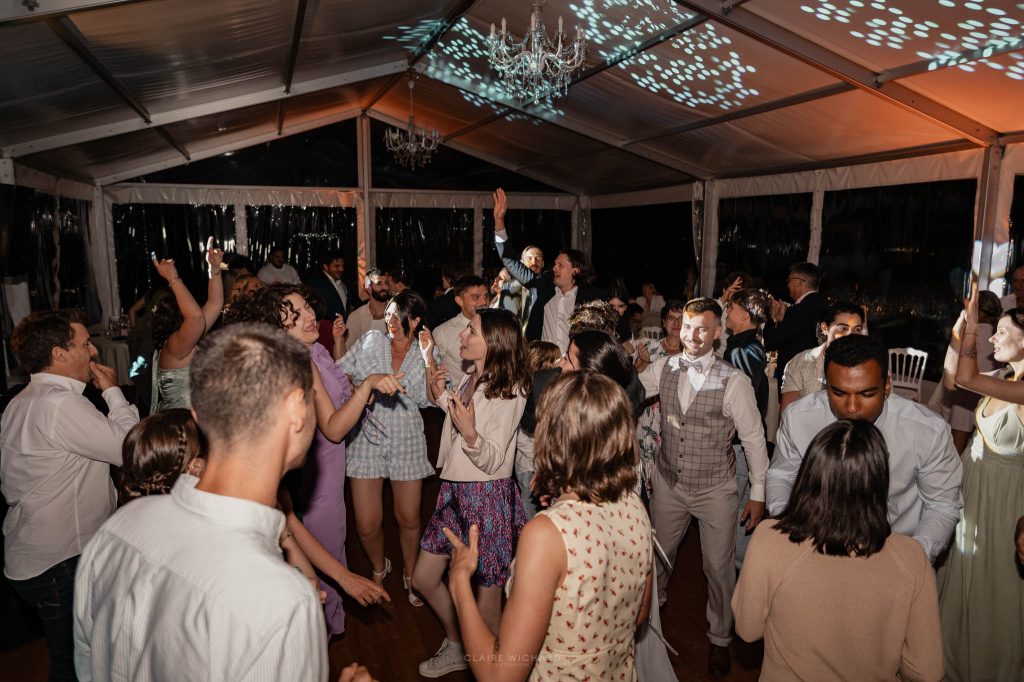 Les mariés et leurs invités s'amusent et dansent ensemble sur la piste lors de la soirée festive du mariage