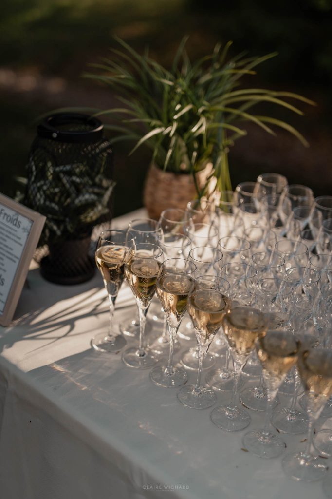 Alignement de flûtes remplies de champagne sur une table nappée de blanc lors du vin d'honneur en extérieur en meurthe et moselle