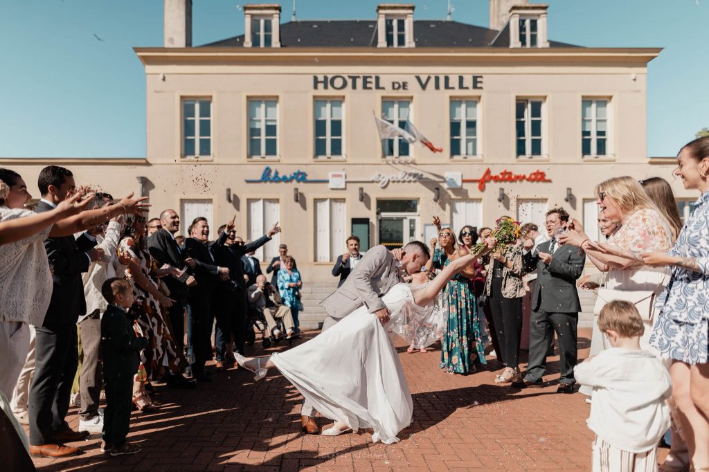 ortie de la mairie de Jarny avec le marié qui bascule sa femme en arrière pour un baiser sous une pluie de confettis.
