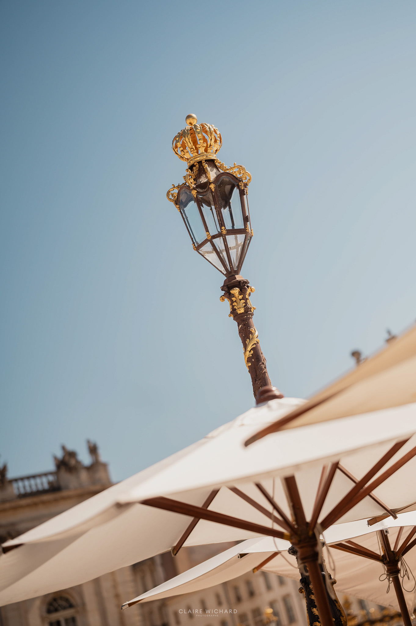Gros plan sur un lampadaire historique en fer forgé doré sur la Place Stanislas à Nancy, photographié par Claire Wichard.
