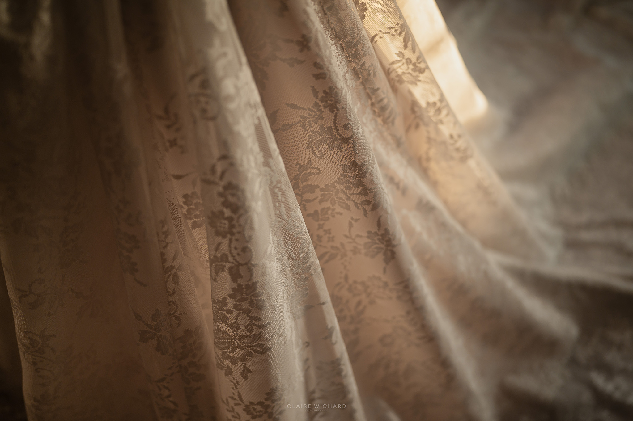 Gros plan sur la dentelle fine de la robe de mariée, lumière douce à l'Abbaye des Prémontrés, photographe de mariage en Lorraine Claire Wichard
