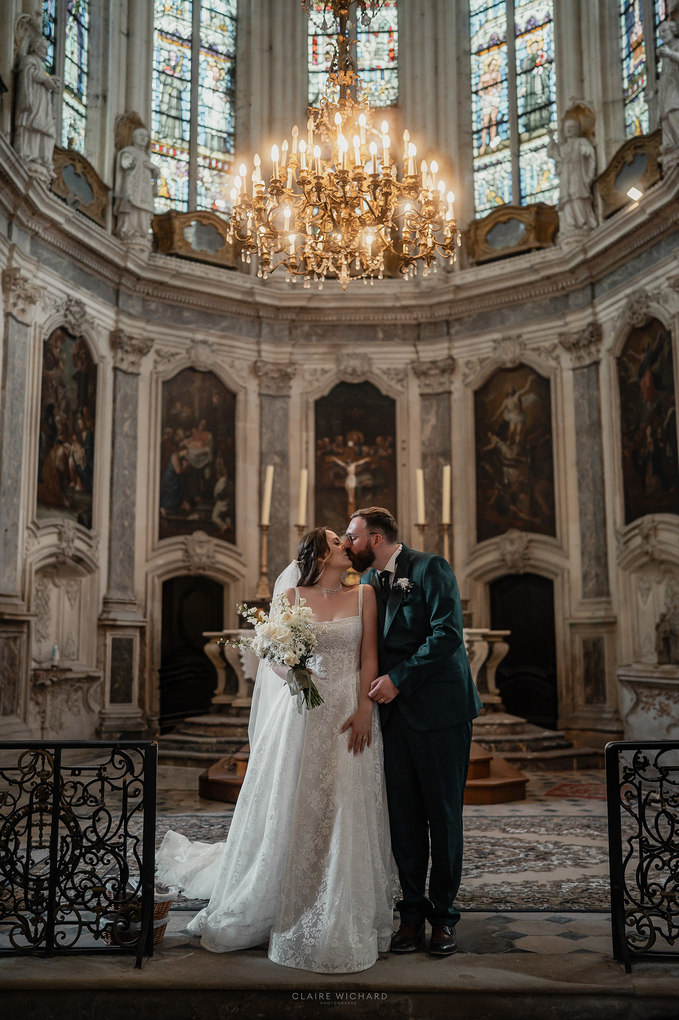 Baiser des mariés sous le lustre de l'église près de l'Abbaye des Prémontrés, reportage mariage en Lorraine par Claire Wichard